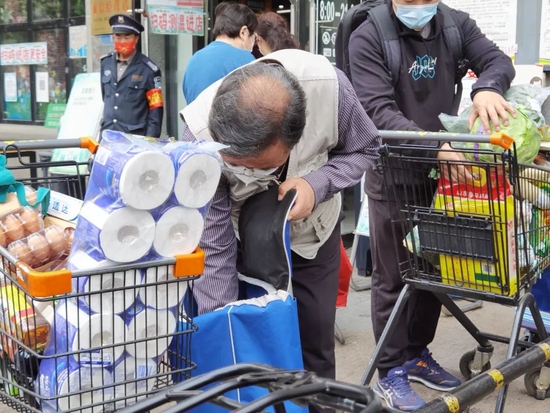 超市门口的购物车装满了采购的物资。摄影：曾靖